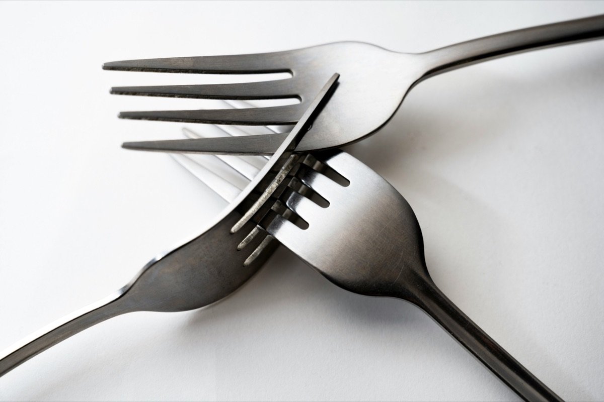 Three forks crossing, their tines locked together