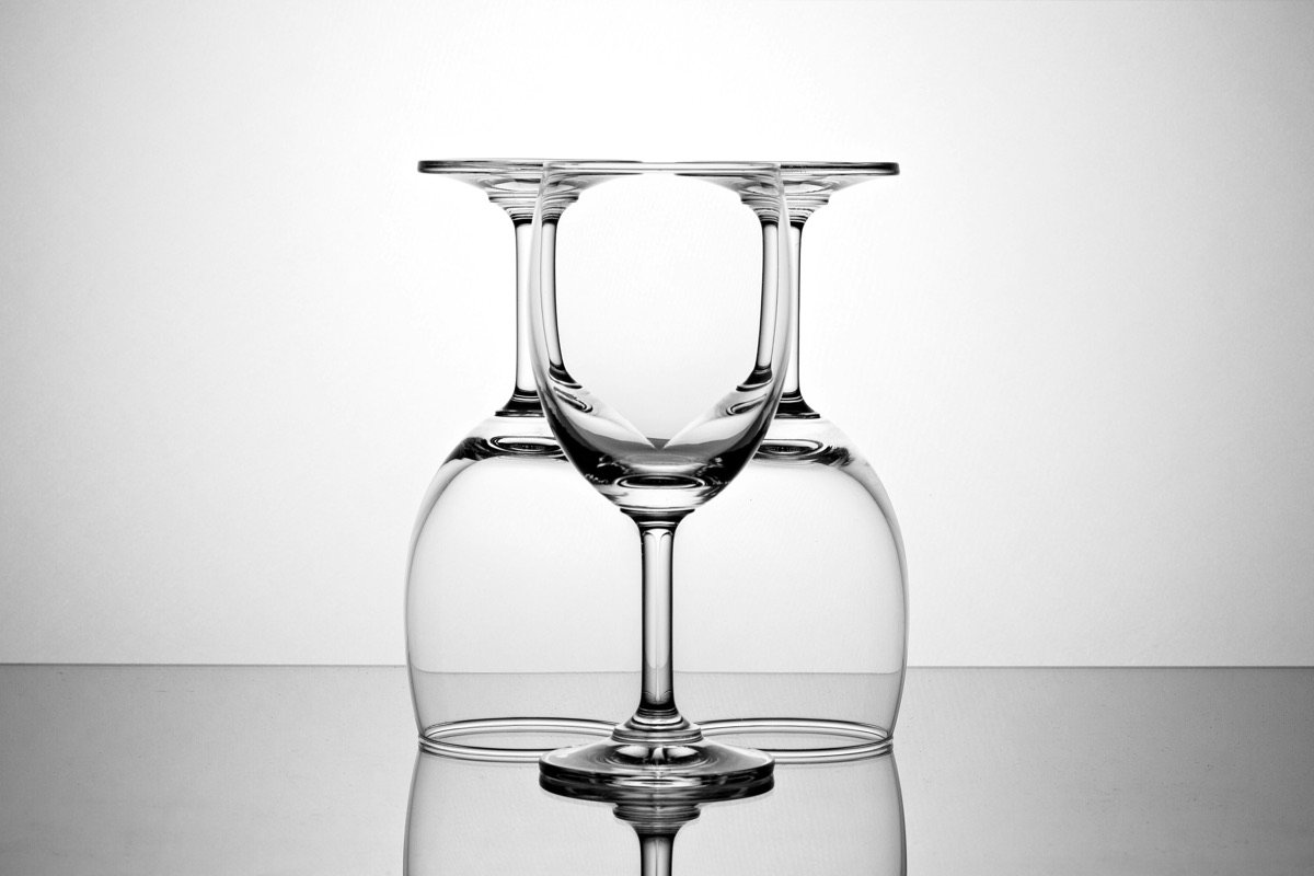 Three wine glasses overlapping, one upright between two upturned